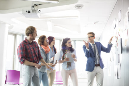 Creative businessman giving presentation to colleagues in office